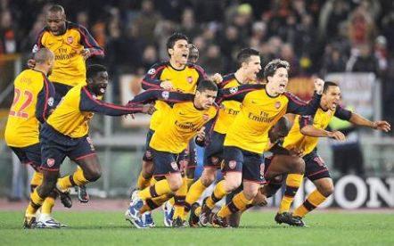 Arsenal players celebrate the winning penalty